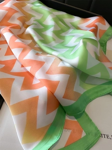 Détail d'un foulard en soie à motif zigzag montrant la texture et le bord de l'ourlet