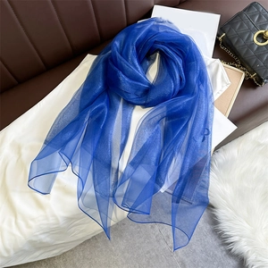 Close-up of dark blue silk scarf with subtle shimmer texture and light translucent fabric