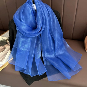 Detail view of vibrant royal blue silk scarf with subtle pearlescent sheen and fine texture