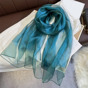 Detail of teal lightweight shiny silk scarf with fine shimmering metallic texture