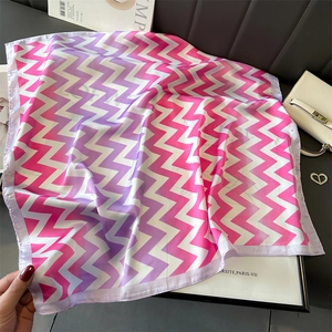 Mise à plat d'un carré de soie dégradé rose avec motif zigzag et accessoires de mode