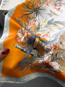 Detailed close-up of bird and floral print on premium satin scarf with silk texture