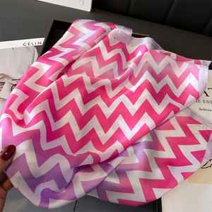 Détail d'un foulard en soie dégradé rose et violet avec des motifs ondulés