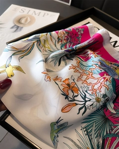 Close-up of lightweight silk scarf featuring vibrant hummingbird and floral prints