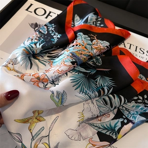 Detail of silk-feel square scarf featuring colorful hummingbirds and tropical leaf prints