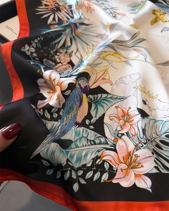 Detail of silk-like square scarf with tropical parrot and lily floral patterns