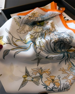 Close-up of silk scarf showing hummingbird floral print and orange border detail