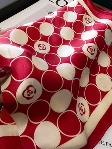 Détail d'un foulard en soie à pois rouges et blancs avec motifs de camélia