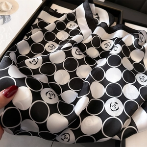 Détail d'un foulard en soie montrant des motifs de camélia et des plis en satin élégant