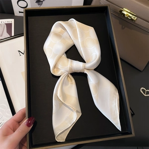 Foulard en soie crème avec motif jacquard géométrique noué en un nœud élégant