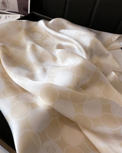 Détail d'un foulard en soie champagne avec motifs camélia et finition nacrée