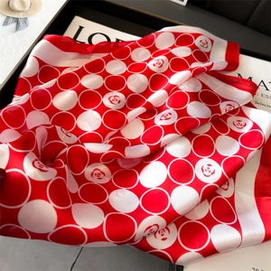 Détail d'un foulard en soie rouge et blanc avec motifs floraux circulaires et doux éclat