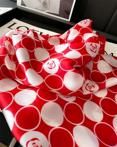 Détail macro du foulard en soie rouge et blanc avec pois et motifs de camélia élégants