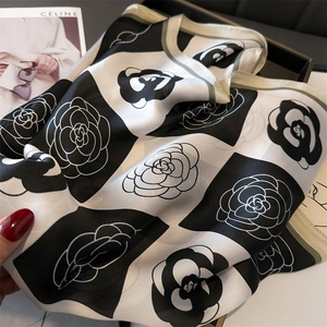 Detail of elegant black and white camellia pattern satin scarf with silk texture