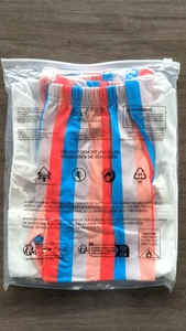 Vue détaillée d'un ensemble rayé coloré dans son emballage en plastique transparent