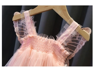 Dettaglio dell'abito in tulle rosa con pieghe elastiche e decoro a ali di farfalla sulle spalle