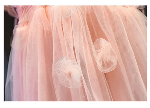 Dettaglio del tessuto in tulle rosa a strati con fiori 3D su un abito tutu da bambina