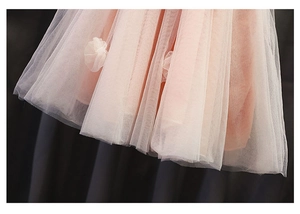 Dettaglio della gonna in tulle rosa a strati con delicate applicazioni floreali