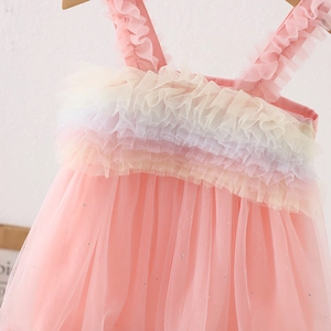 Detalle de vestido de princesa rosa con volantes de malla arcoíris y lentejuelas plateadas