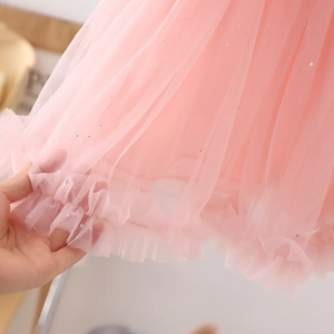 Detalle del tejido de tul rosa en capas con sutiles destellos plateados y brillantes