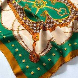 Detail of baroque silk scarf featuring golden chains, keys and green satin texture