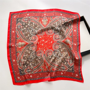Detail of vintage red paisley print silk-like square scarf with intricate floral patterns