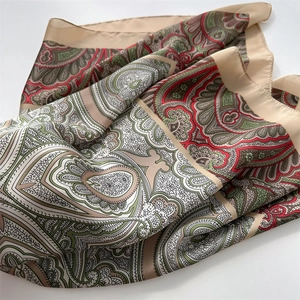 Macro view of paisley print pattern and beige satin border on a vintage square scarf