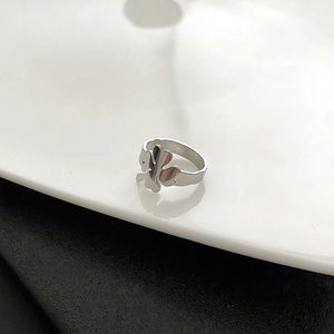Polished silver stainless steel four-leaf clover ring for women on monochrome background