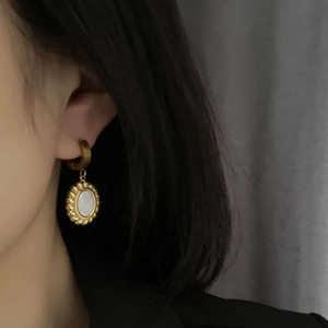 French retro mother of pearl earrings in gold plated titanium steel on a female model