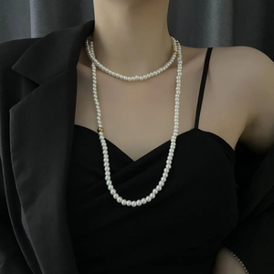 Elegant multi-layer faux pearl long sweater necklace with gold accent beads on a model