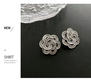 Detailed view of silver camellia earrings with pavé set cubic zirconia and petals