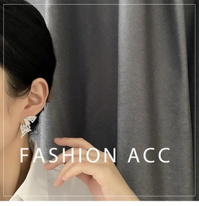 Close-up of elegant butterfly wing earrings with white rhinestones on a female model