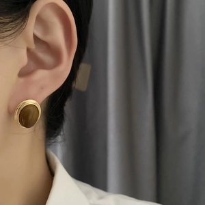 Vintage oval tiger eye stone earrings with a gold metal frame on female model