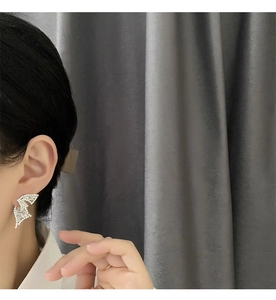 Detail of lightning bolt earrings with pavé crystals on silver metal base for women