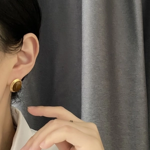 Vintage gold stud earrings with oval tiger eye stones shown on a female model