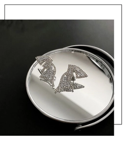 Macro view of silver geometric wing earrings with high-quality cubic zirconia stones