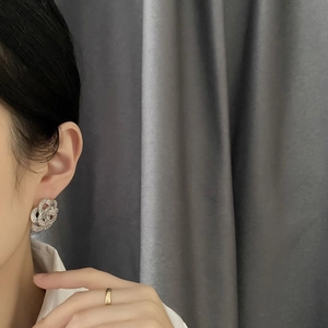 Elegant floral silver knot earrings with pavé crystals shown on a female model