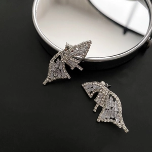 Sparkling silver butterfly earrings with pavé zircons on a reflective mirror background