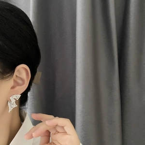 Elegant silver lightning wing earrings with sparkling crystals shown on model