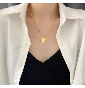 Detail of gold heart pendant with I Love You engraving and beaded choker chain