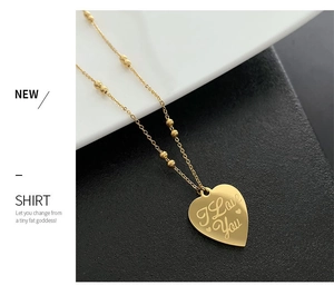 Macro shot of gold heart pendant with I Love You engraving on a beaded link chain