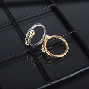 Macro detail of gold and silver twisted cable rings with pavé diamond cylinder ends