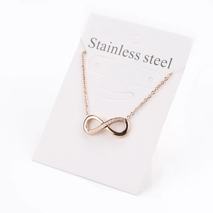 Macro detail of rose gold infinity pendant with white crystals on stainless steel chain