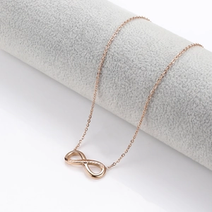 Macro shot of rose gold infinity pendant necklace with delicate crystal inlay details
