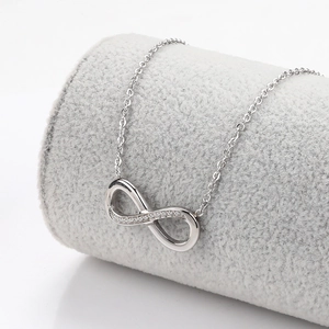 Macro detail of infinity pendant necklace featuring pave-set cubic zirconia on silver steel