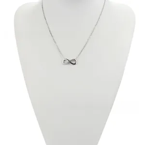 Detail of silver infinity pendant necklace featuring crystals on a white neck model