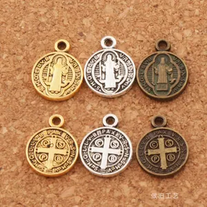 Religious St. Benedict medals in gold, silver, and bronze on cork background