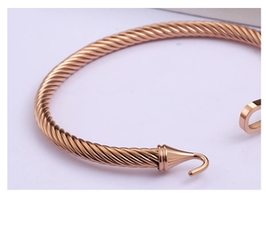 Detail view of rose gold cable twist bangle with horse hoof clasp closure