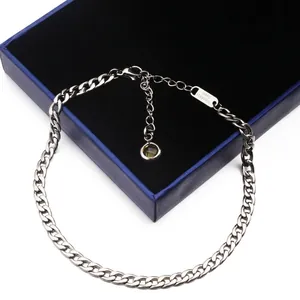Minimalistische Edelstahl-Ankerkette mit braunem Kristallanhänger auf blauer Geschenkbox