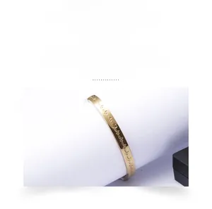 Detailed view of gold titanium steel bangle featuring hollow Roman numeral design